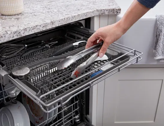 womans-hand-loading-third-rack-maytag-dishwasher